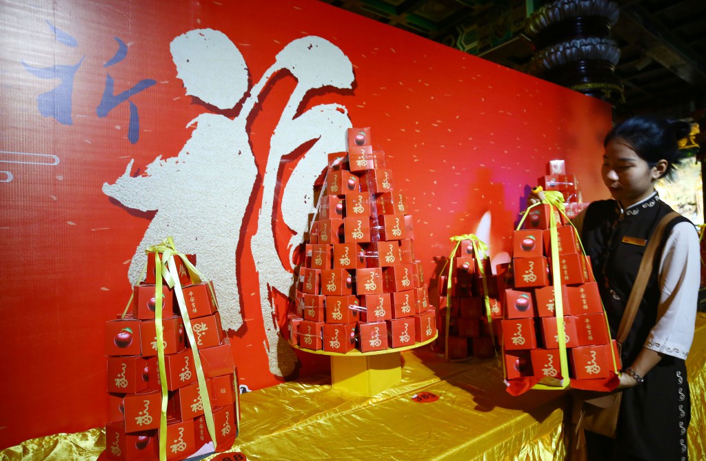 2月8日,工作人員在三亞南山迎財神廟會活動中準備擺放水果。 2月8日,工作人員在三亞南山迎財神廟會活動中準備擺放水果。